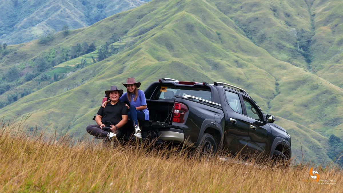 A couple sitting on the tailgate of their pickup on a Cebu hillside
