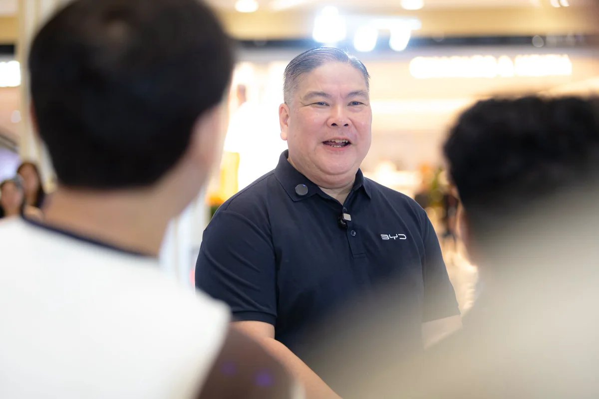 A product consultant mid-conversation with shoppers at a mall display