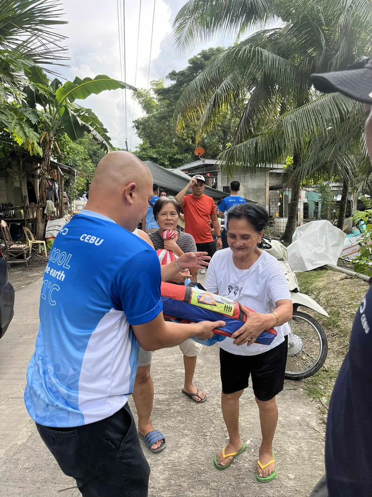 A volunteer handing a relief package to a resident